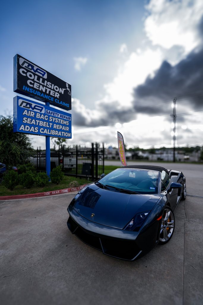 DNA Collision Center sign with a customer car parked outside the shop in Houston