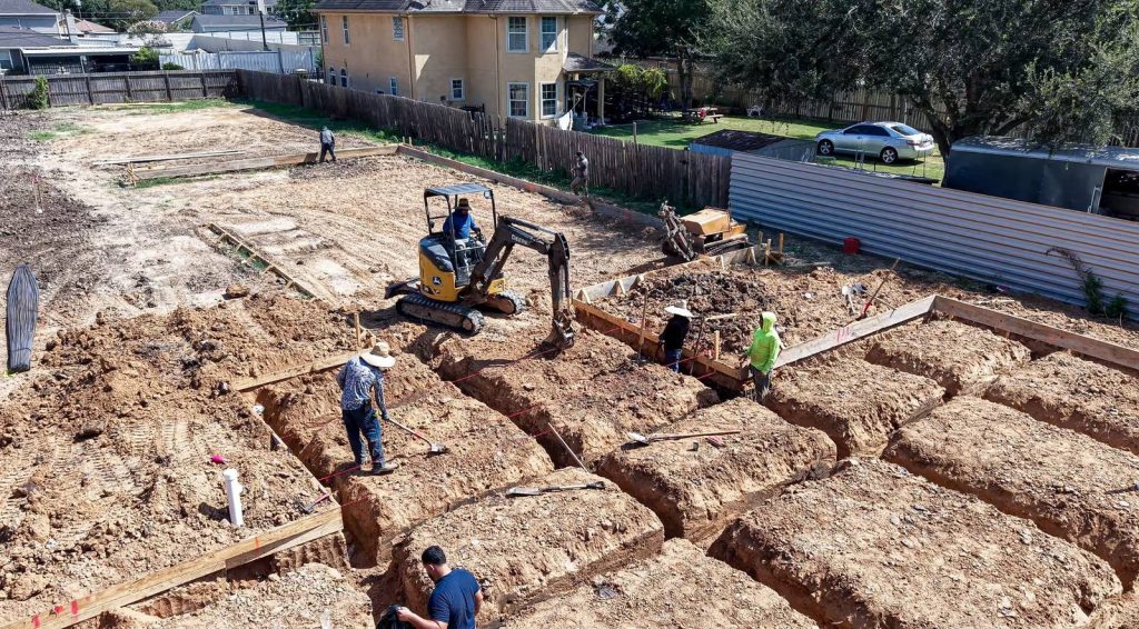Construction crew digging foundation trenches for a new home build