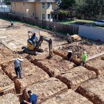 Construction crew digging foundation trenches for a new home build